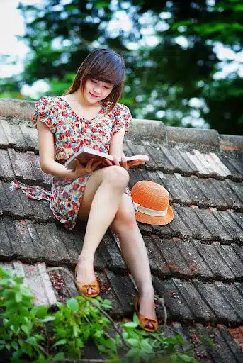 girl reading a book on the house roof